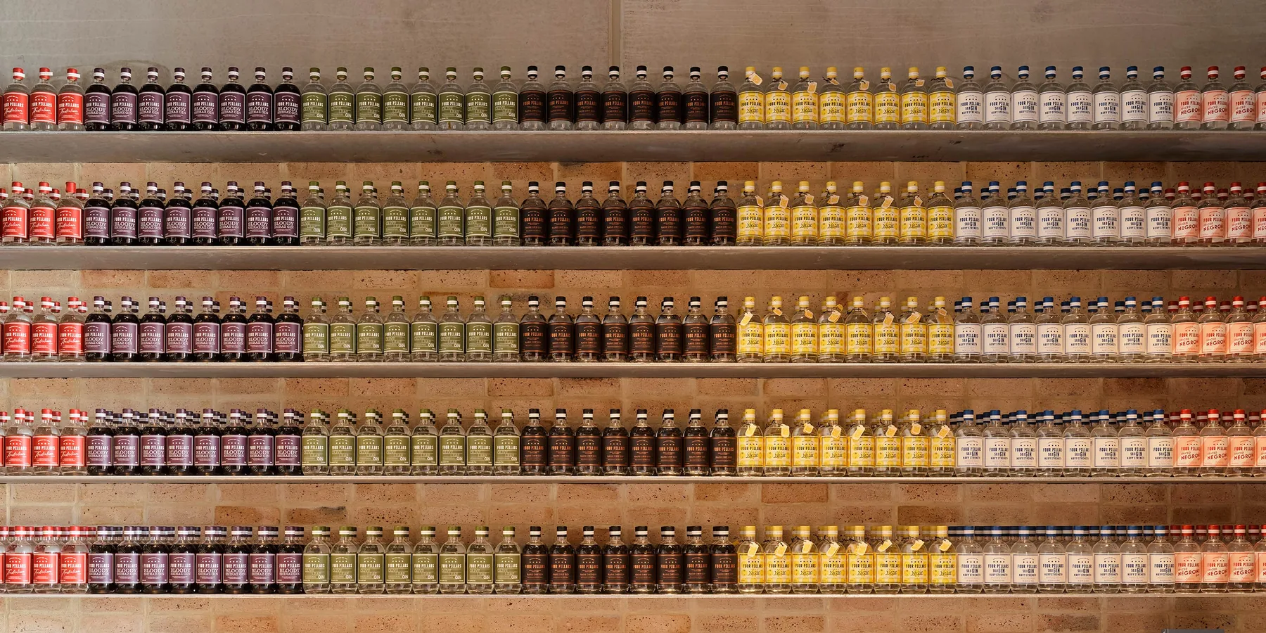 Rows of gin bottles ranked by colour along recycled brick shelving