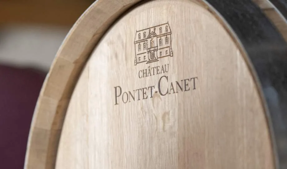 The head of an oak barrel branded with the chateau engraving and the name Chateau Pontet-Canet