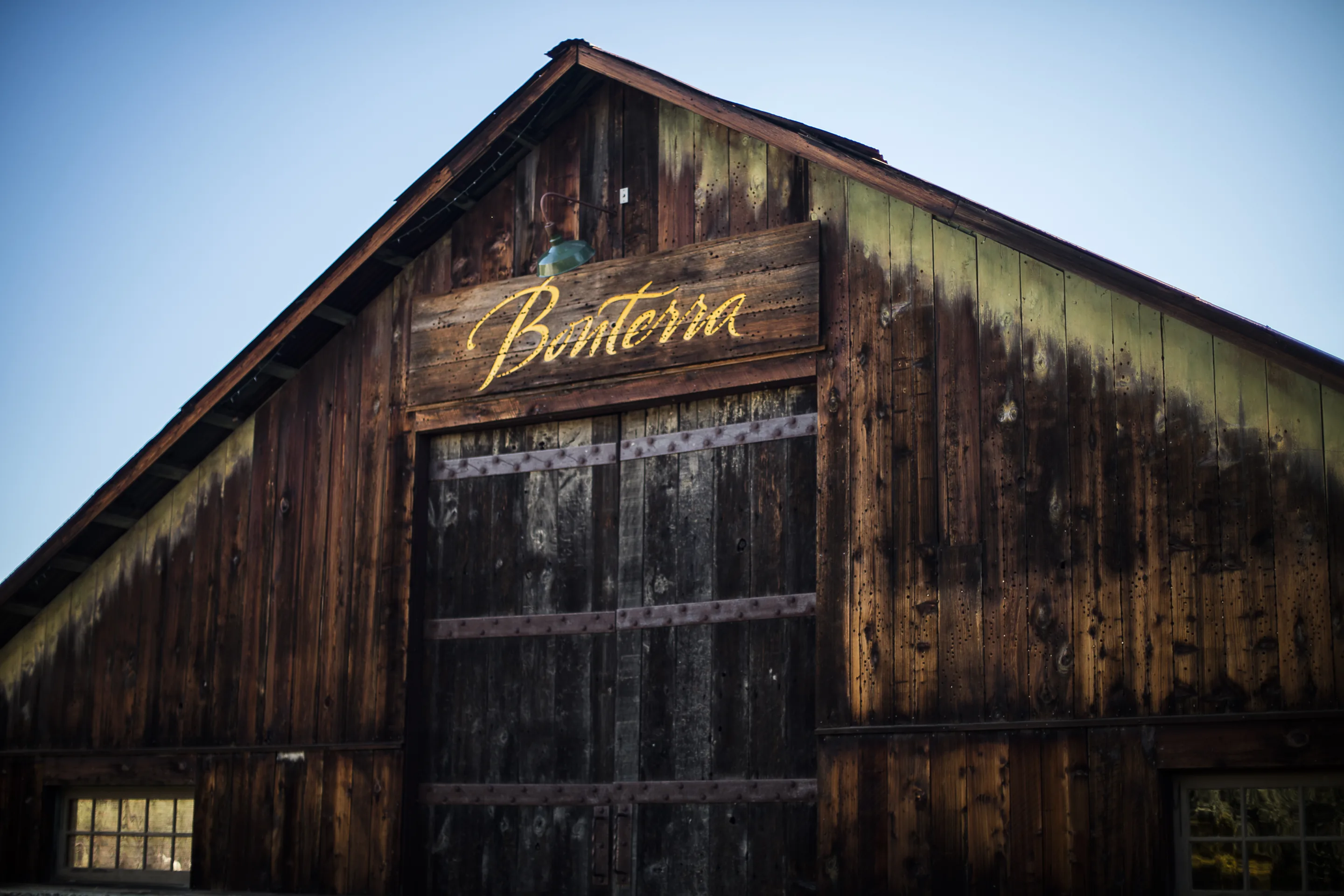 Weathered timber barn with the name Bonterra in gold script over its doors, against a blue sky