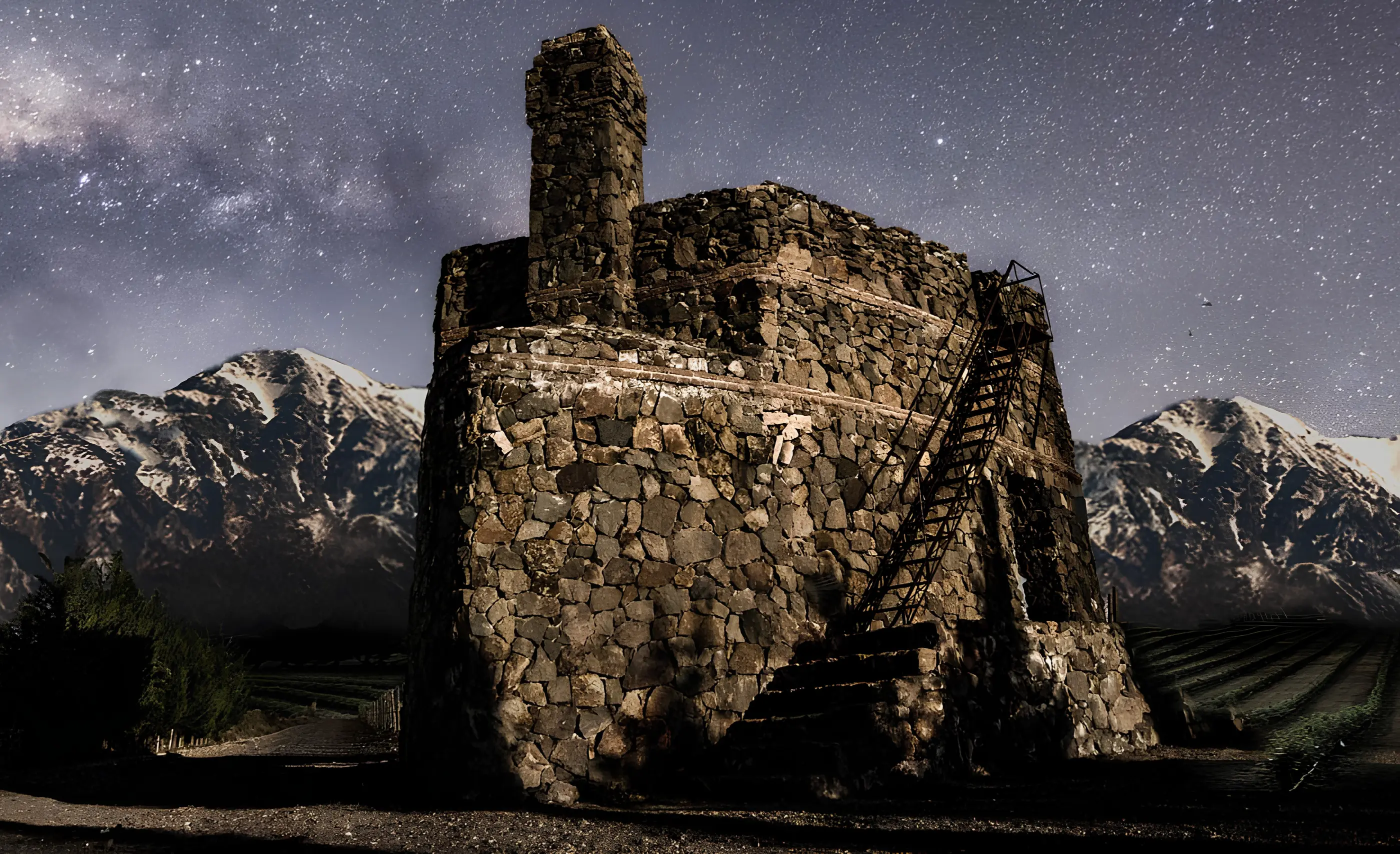 Stone pyramid-shaped winery with an outside staircase under the Milky Way and snow-capped Andes, at Catena Zapata in Agrelo