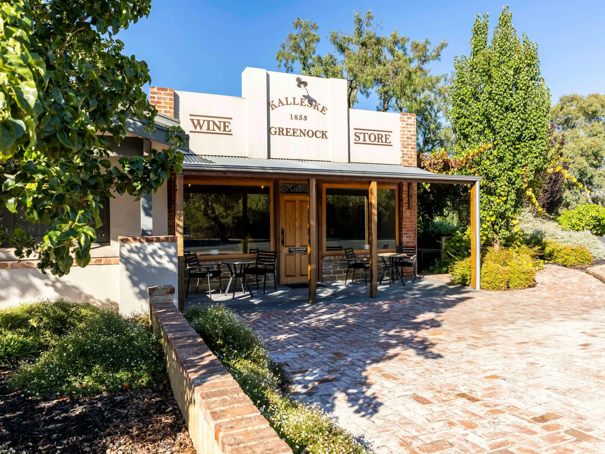 The Kalleske Greenock Wine Store cellar door, a brick and render building with a veranda and tables, on a brick-paved forecourt