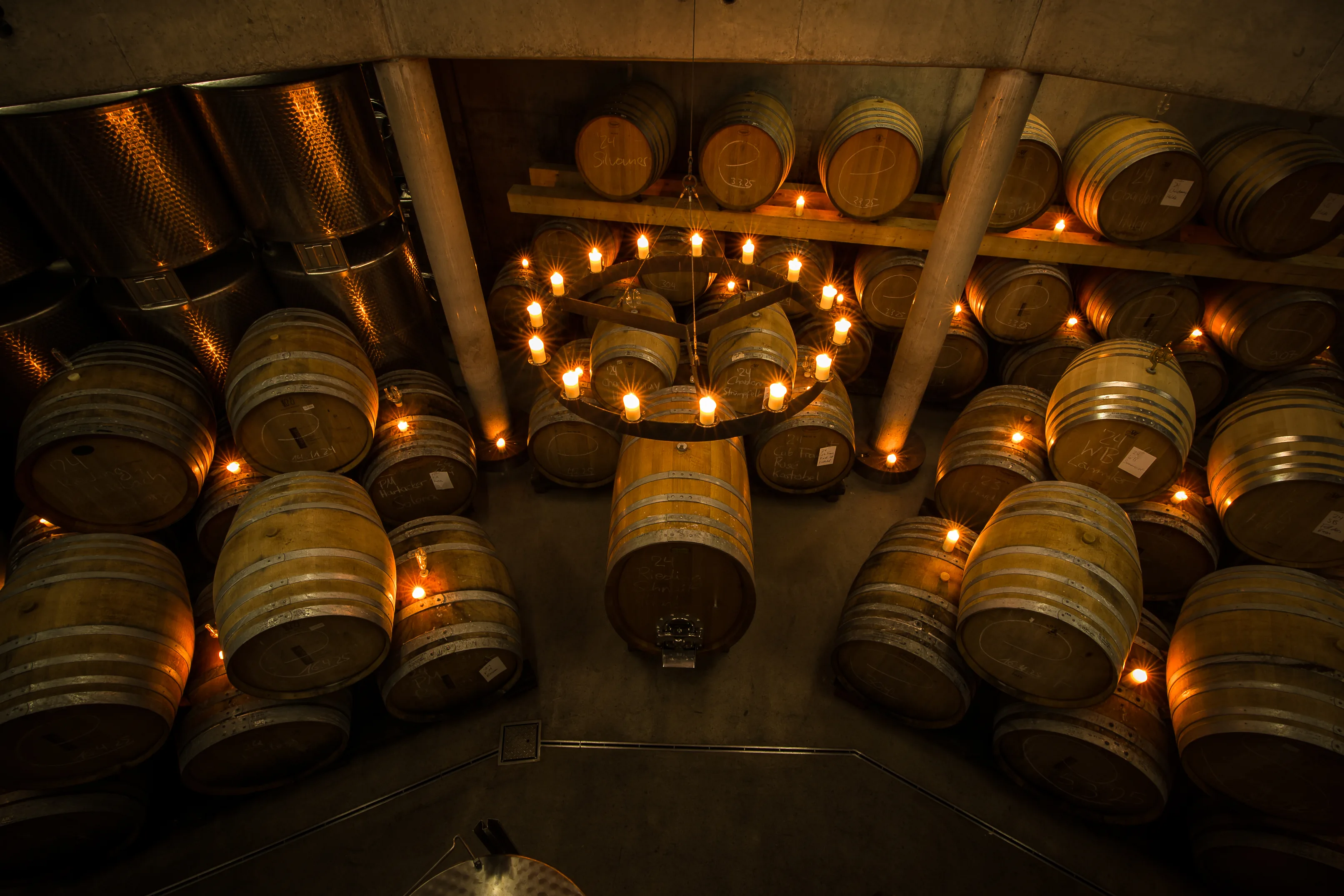 Looking down into the barrel cellar at Weingut Rainer Schnaitmann, barrels and steel tanks lit by a ring of candles